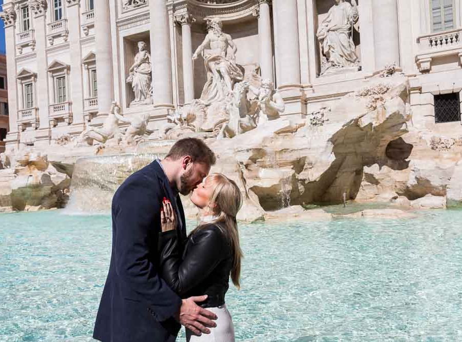Kissing at the Trevi fountain during an engagement photo shoot in Rome