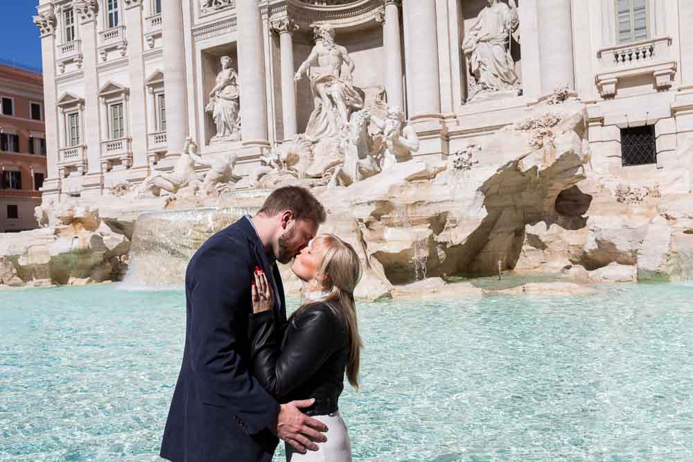 Kissing at the Trevi fountain during an engagement photo shoot in Rome