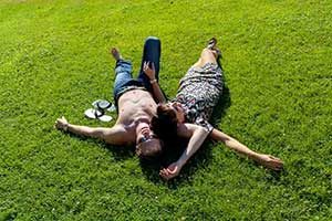Couple laying down on green grass