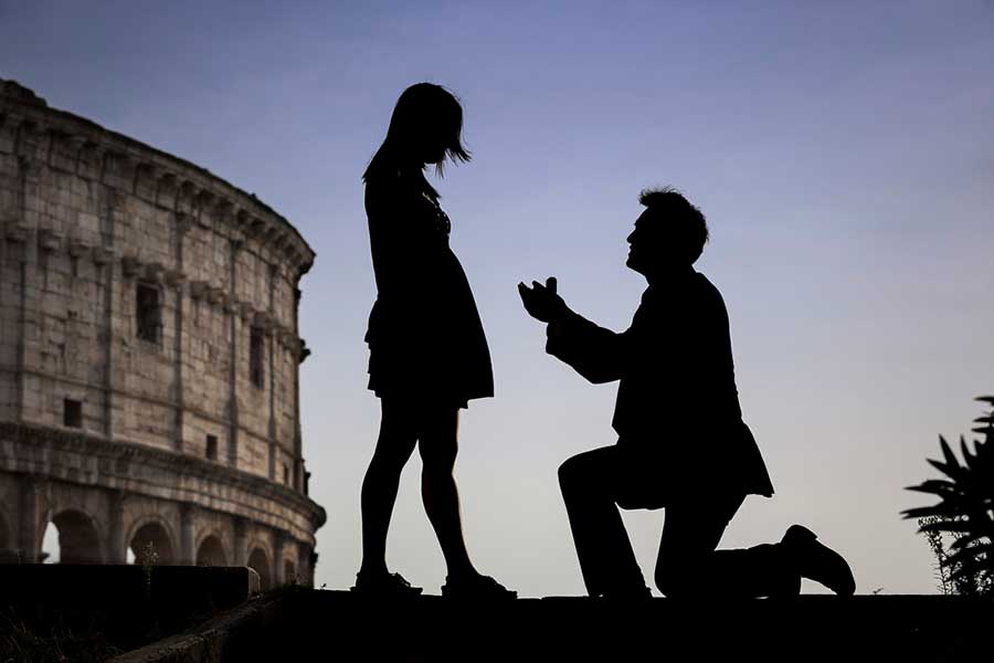 Surprise Wedding Proposal Photographer in Rome Italy. Image taken at the roman Coliseum at sunset where he dropped to one knee and proposed