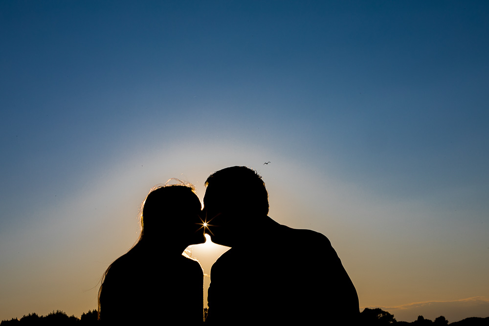 Silhouette couple against sunlight at dusk