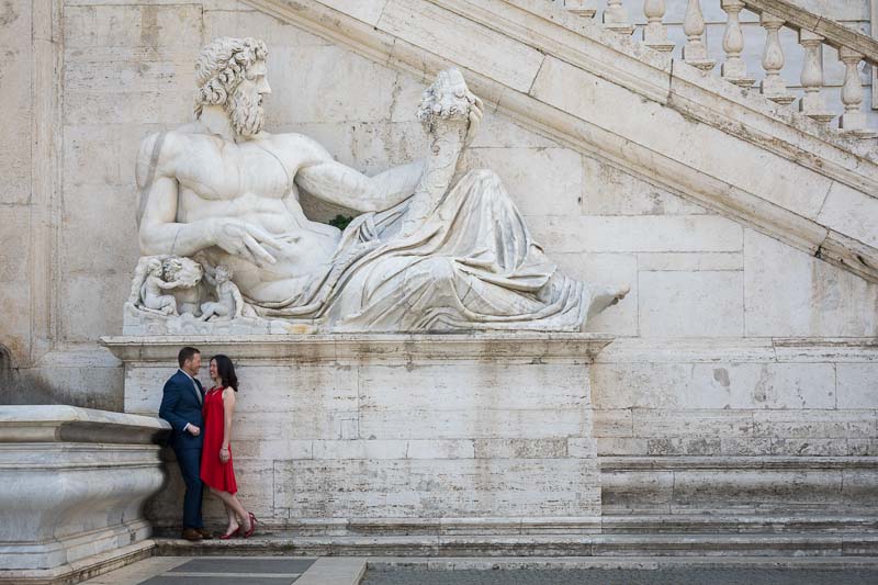 Standing pose underneath a large marble roman statue