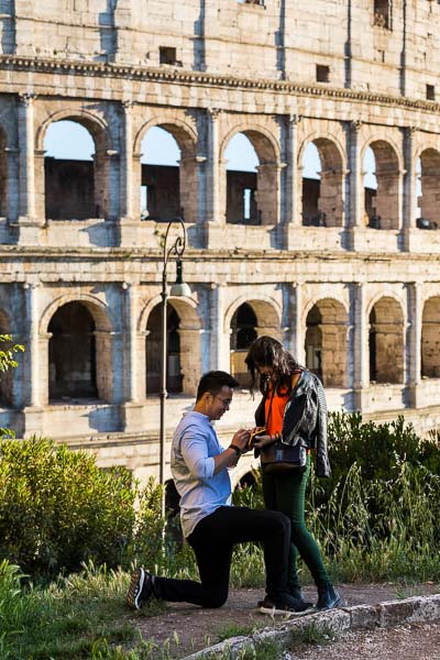 Secret wedding proposal. Asking the big question on a hill overlooking the roman Coliseum