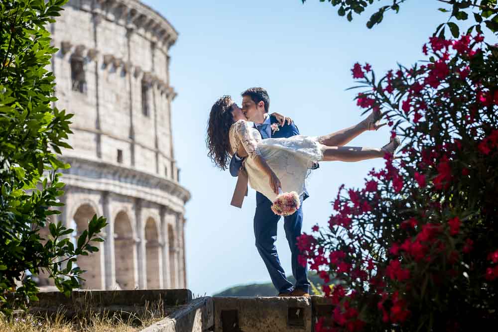 Groom holding bride with the Colosseum large in the background