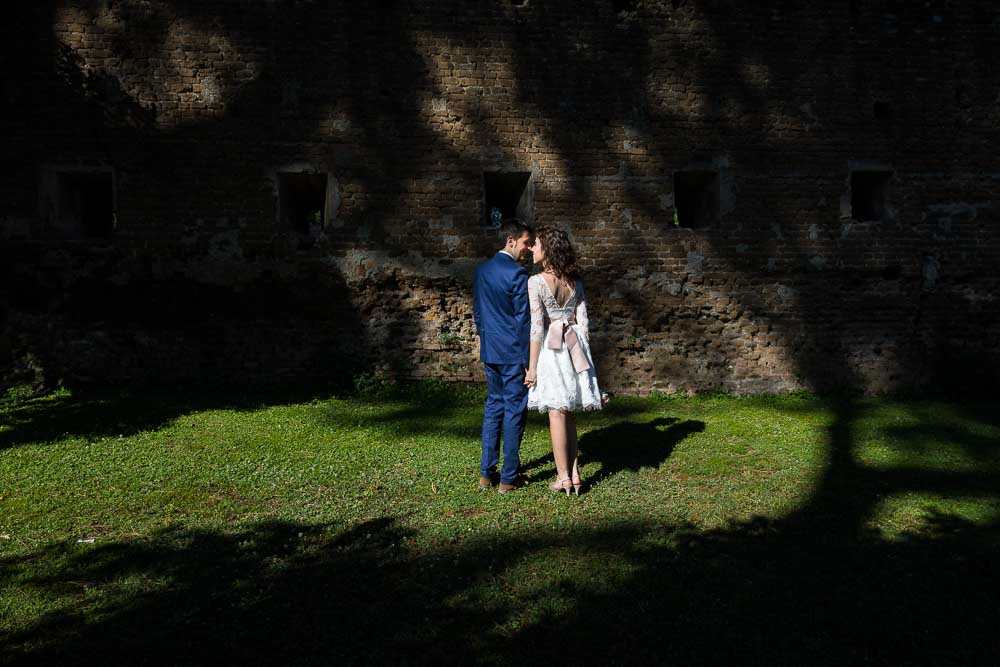 Bride & groom portrait picture in a park among light and dark contrast areas