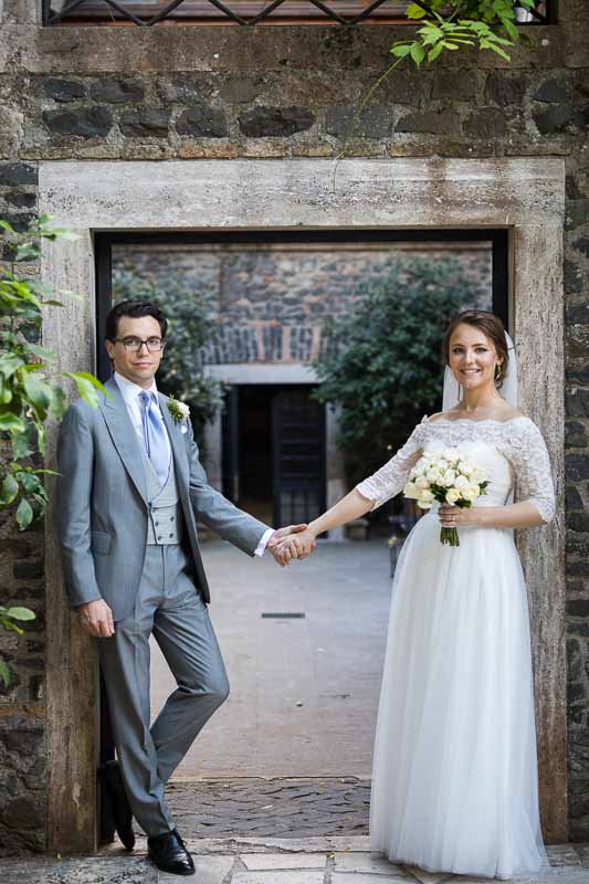 Posed portrait pf bride and groom standing under a doorway