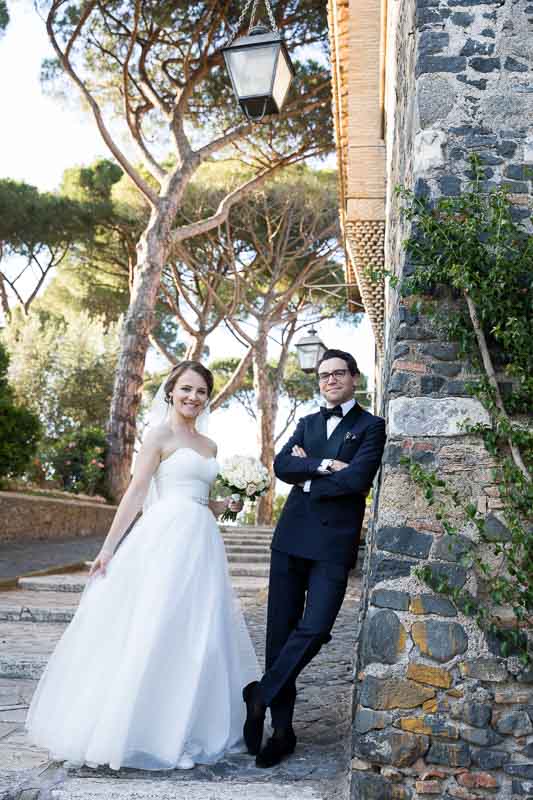 Evening wear bride and groom posing by the roman castle