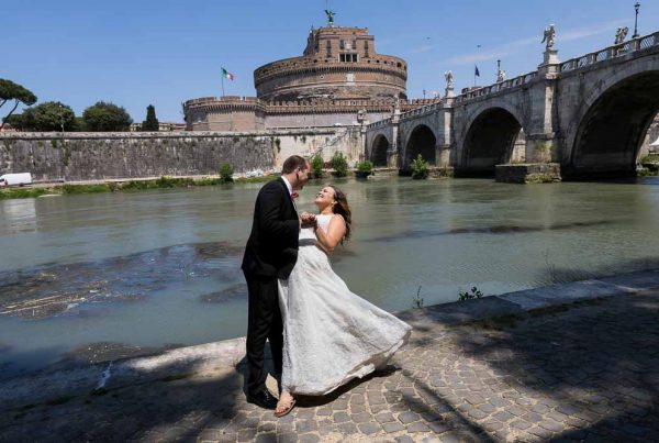 Wedding couple posing under Castel Sant Angelo bridge