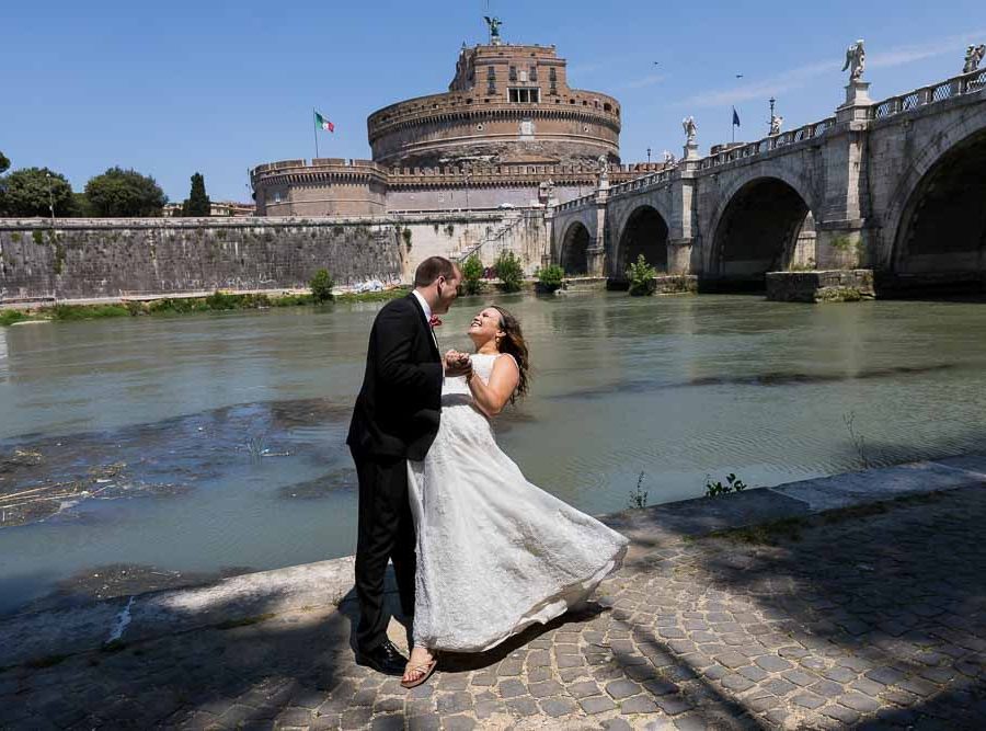 Wedding couple posing under Castel Sant Angelo bridge