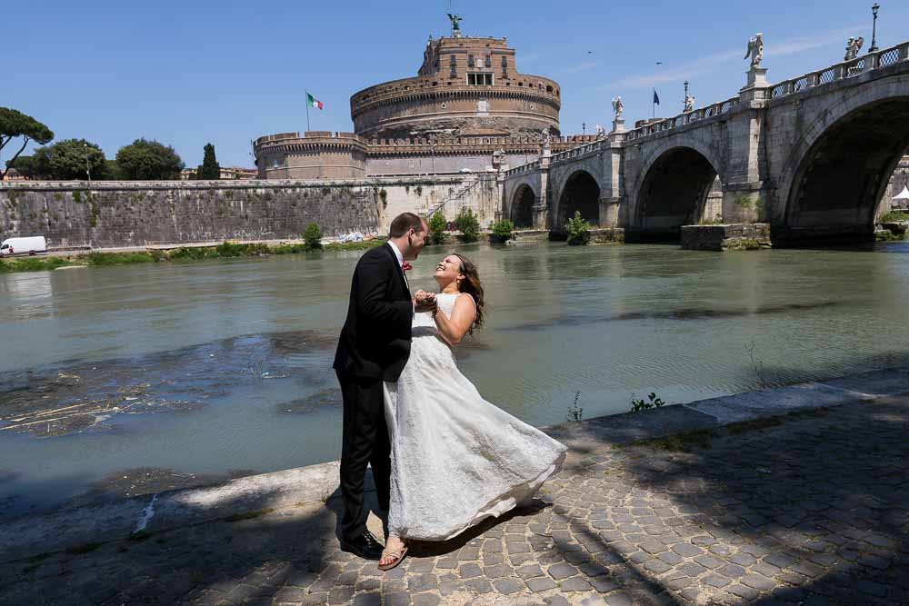 Wedding couple posing under Castel Sant Angelo bridge