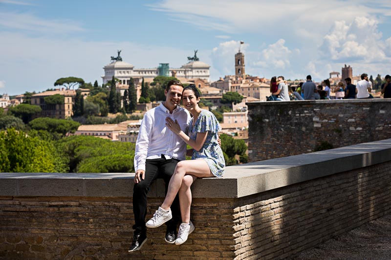 Couple sitting down before the scenic view of the roman skyline