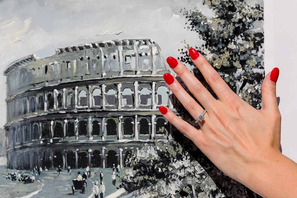 Photo of the engagement ring by a Colosseum painting. Engaged in Rome. Roman Pantheon Proposal