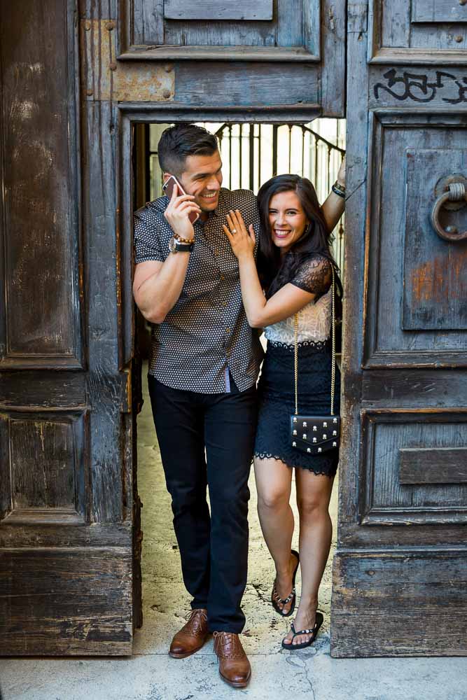 Close together posing underneath a wooden doorway