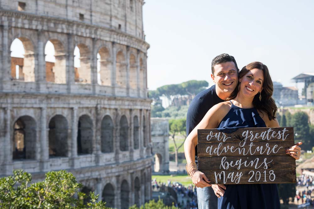 Portrait picture by the Colosseum holding a a sign