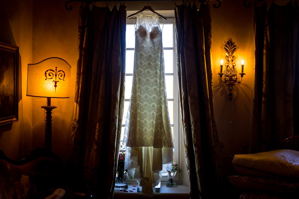 The bridal dress hanging from the window