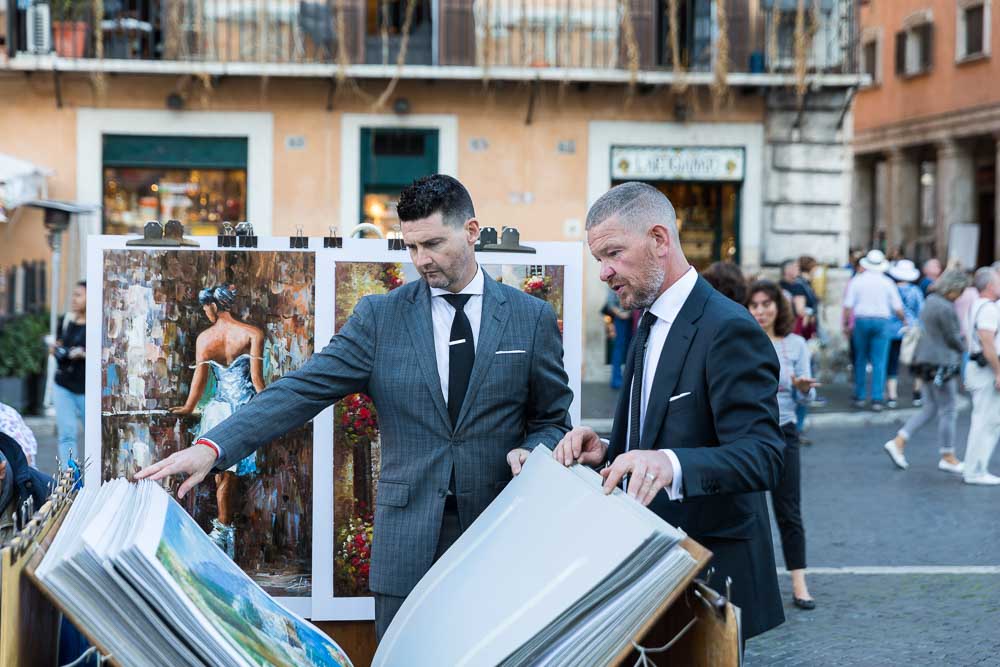 Flipping through poster paintings in Piazza Navona