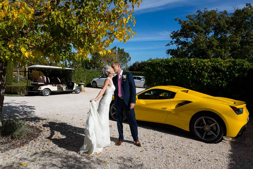 Newlyweds with a bright yellow Ferrari sports car