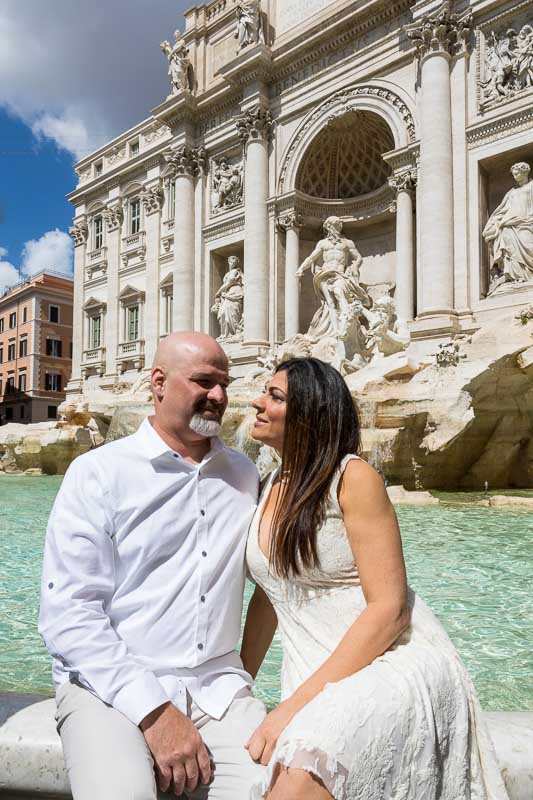 Coupe sitting down posing on the water edge of the Trevi fountain