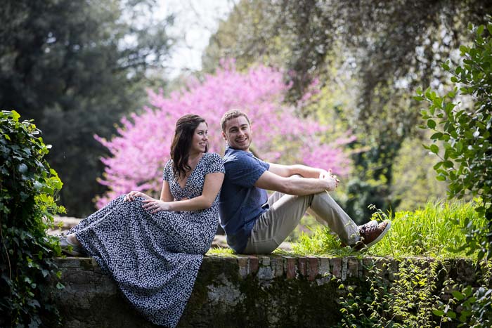 Final couple portrait sitting down on a ledge with a colorful tree in the background