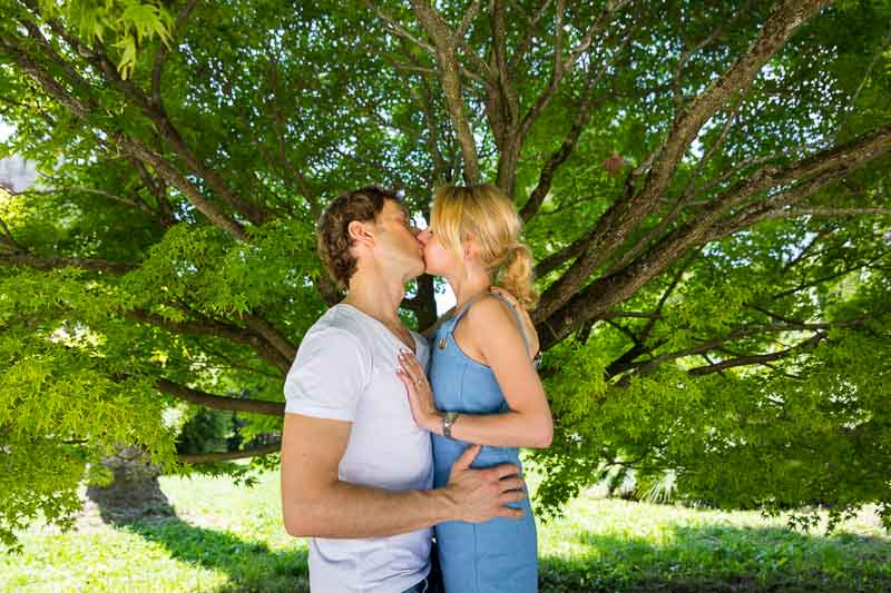 Couple kissing underneath a tree