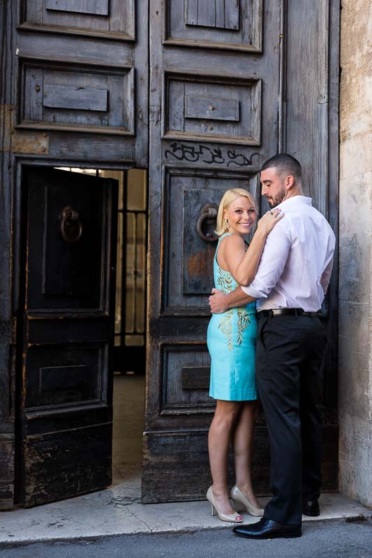 Couple posing in front of an old doorway in the roman streets