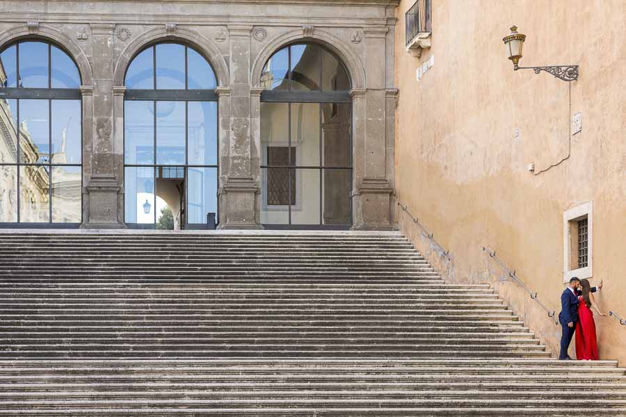 Love story photo book of being together in Rome standing on stairs under a light pole