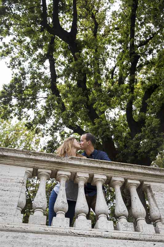 Kissing underneath tree on a terrace overlook