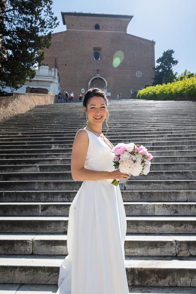 Radiant bride portrait standing on the steps of Church Basilica di Santa Maria in Ara coeli in Rome