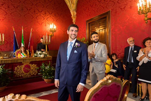 The groom looking at the bride as she enters the red room