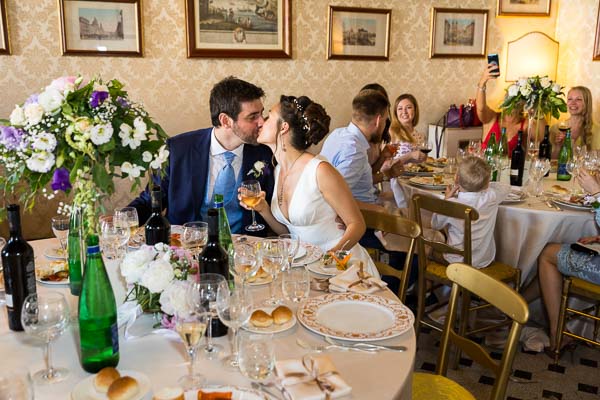 Groom and bride kissing during the lunch reception