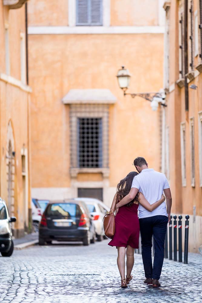 Romantic image of couple walking together in the roman alleyway streets . Rome, Italy