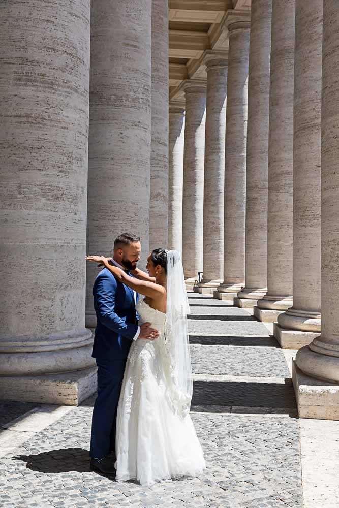 Bride and groom posed photo under the Saint Peter's colonnade in the Vatican