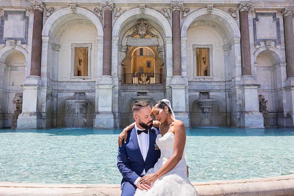 Portrait picture sitting down on the edge of the Fontanone water fountain. Bride and Groom photography