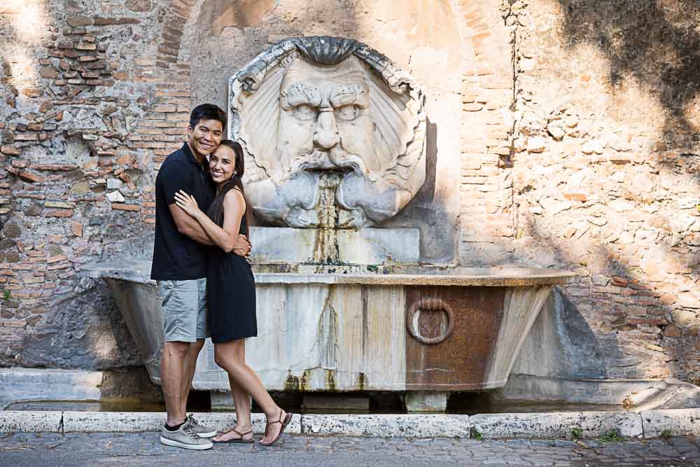 Posing before the ancient water fountain found at the park entrance