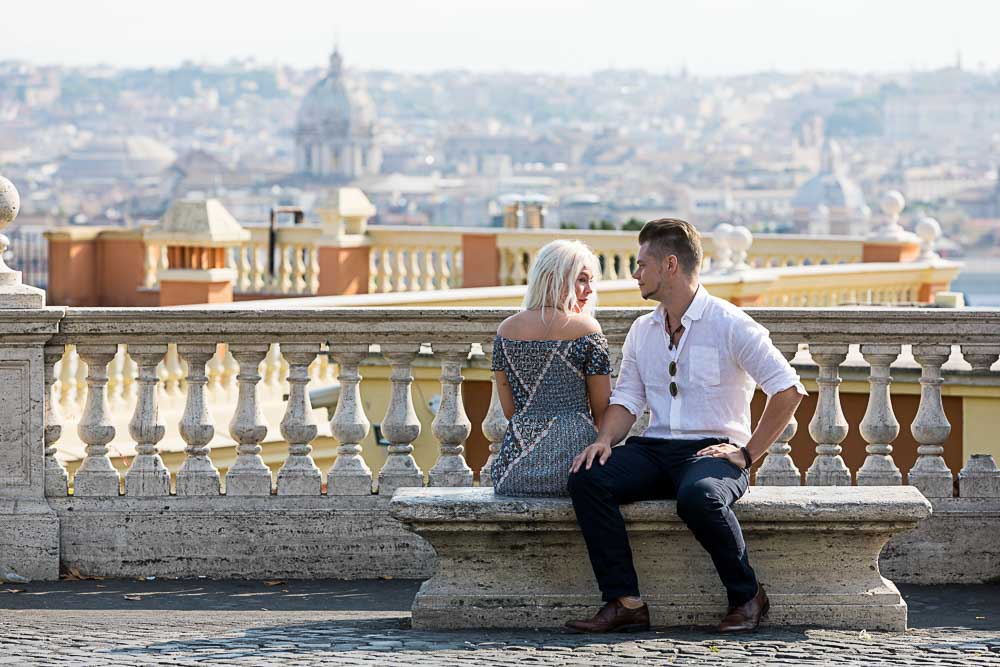 Sitting down couple portrait overlooking the beautiful roman city in the distance