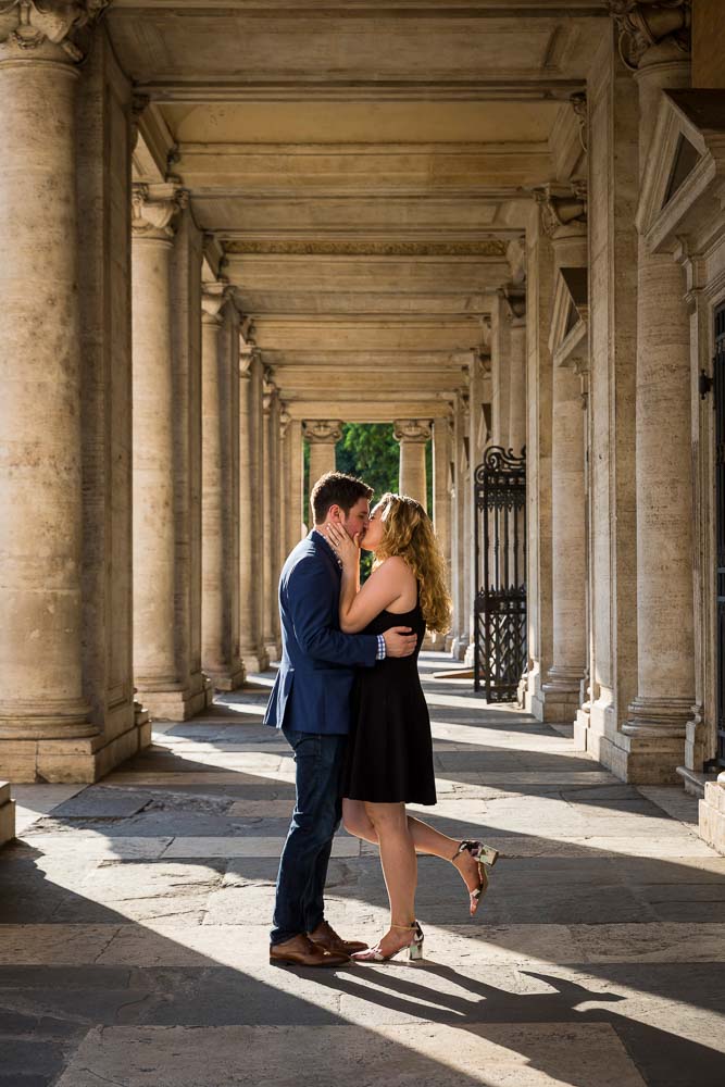 Kissing in between ancient columns in sun shining light