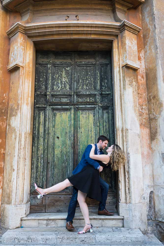 Dipping in front of a large and old green door