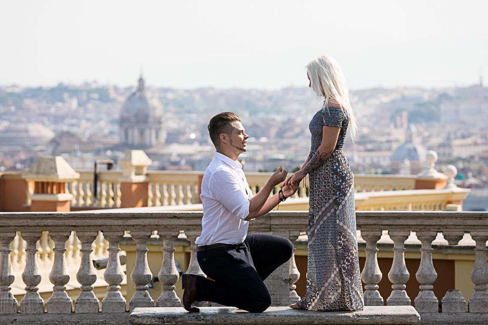 Kneel down Surprising Wedding Proposal at the Janiculum hill in Rome Italy photographed from a distance