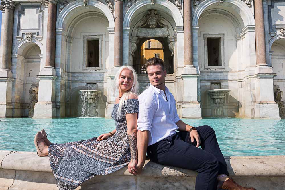 Just engaged portrait picture sitting down on the water fountain edge