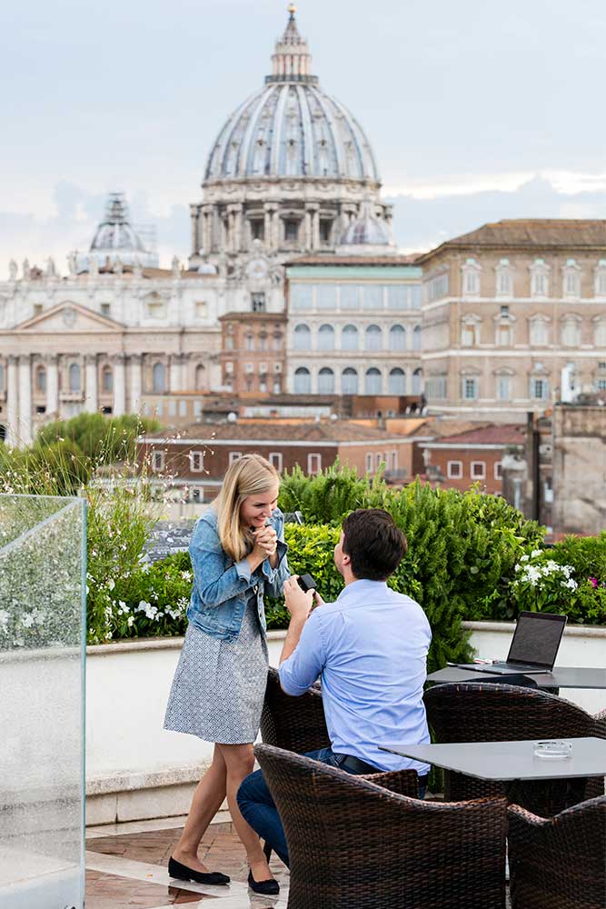 Man proposing on a terrace over a unique view over Rome's Saint Peter's cathedral in the far distance