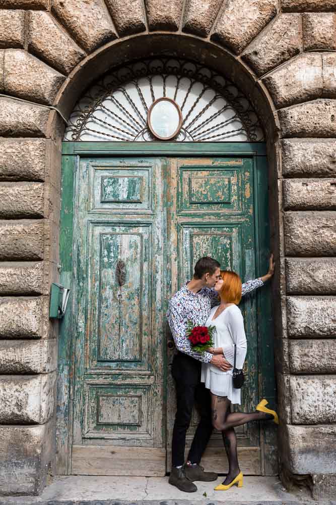 Couple portrait picture standing and kissing in front of an old door