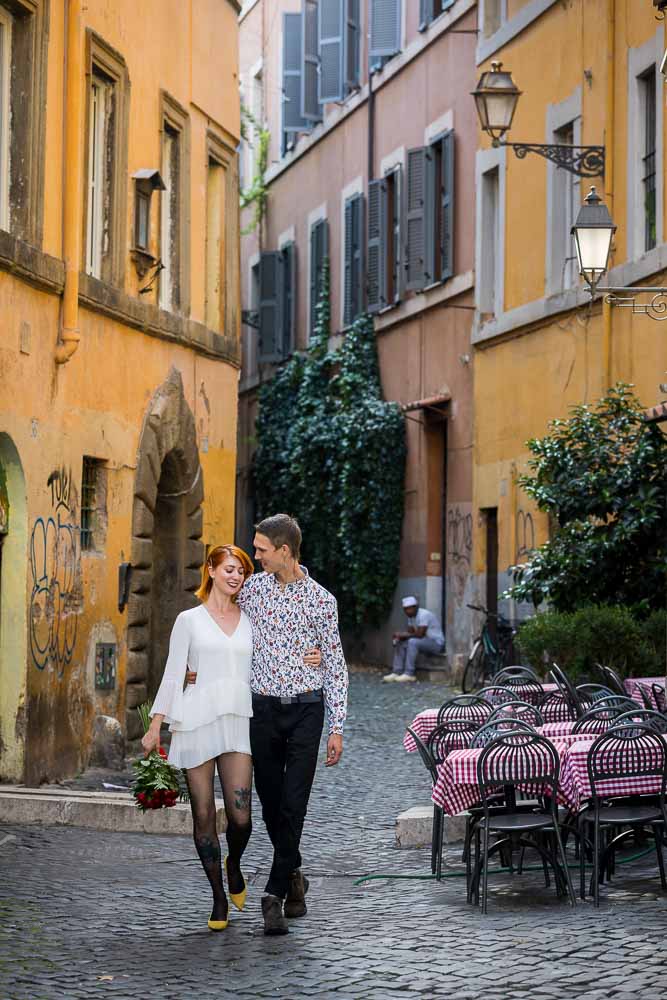 Romantic picture of a couple walking close together in the characteristic streets of Rome Italy