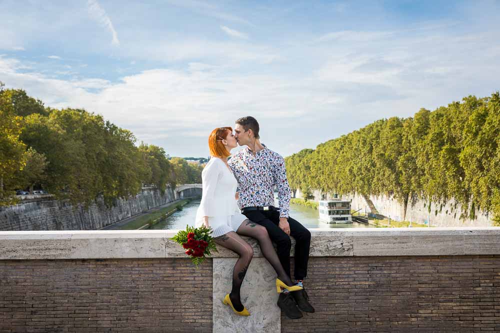 Sitting down pose before the Tiber river with blue sky above