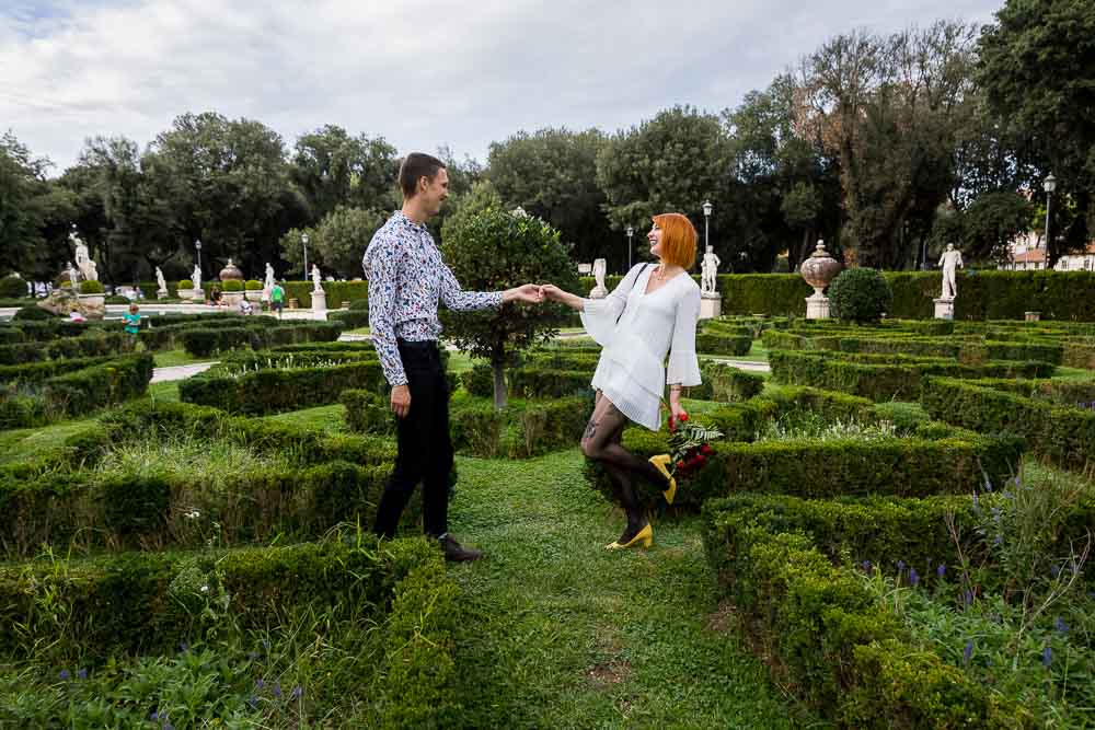 Taking pictures together in a green garden behind Galleria Villa Borghese