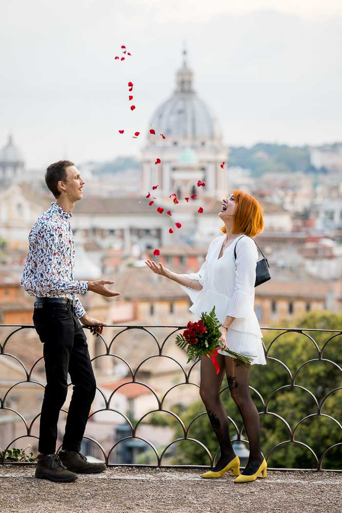 Throwing rose petals in the air from Parco del Pincio overlooking the roman skyline from above