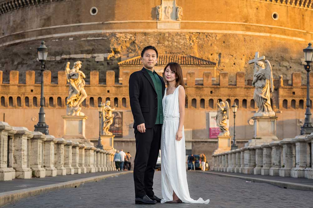 Wedding Couple Photo Session Photography in Rome Italy standing on the ponte Castel Sant'Angelo. Early morning portrait