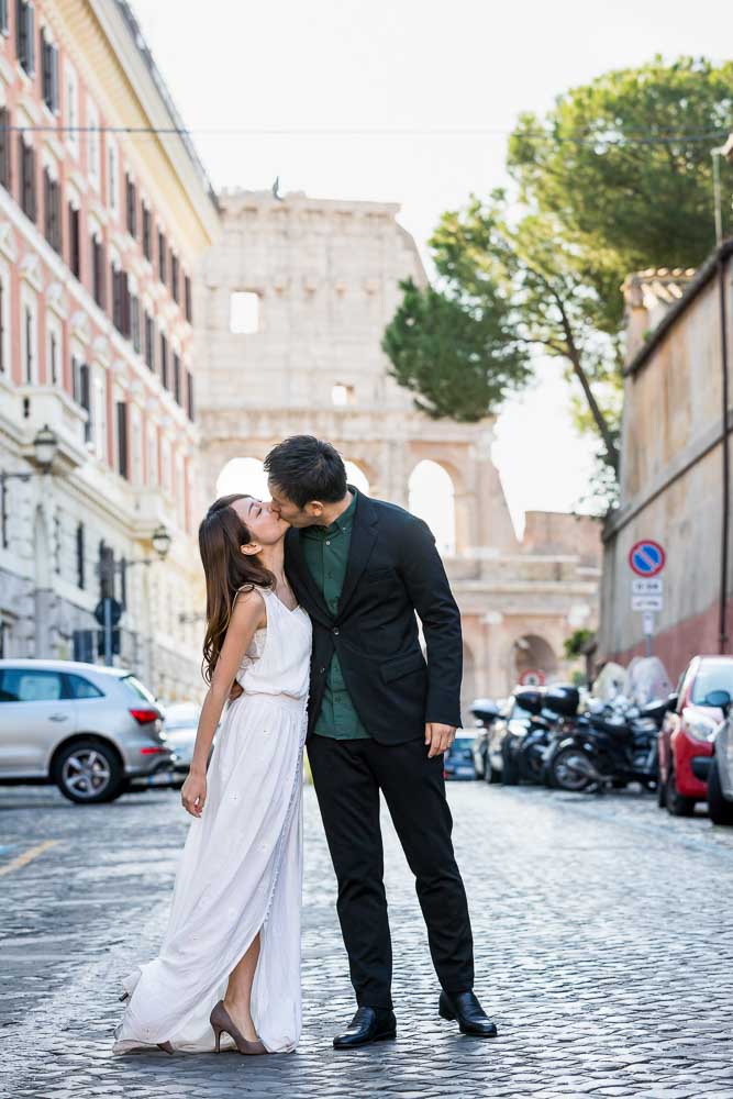 Kissing in the cobble stone alleyway with the Coliseum as backdrop