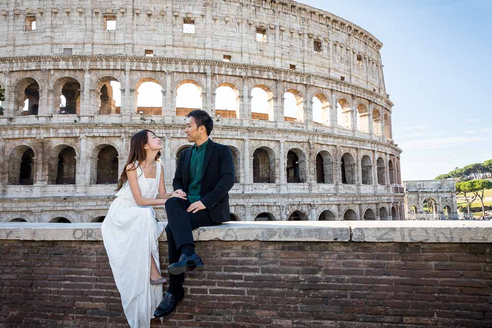 Portrait picture sitting down on a ledge before the roman Colosseum