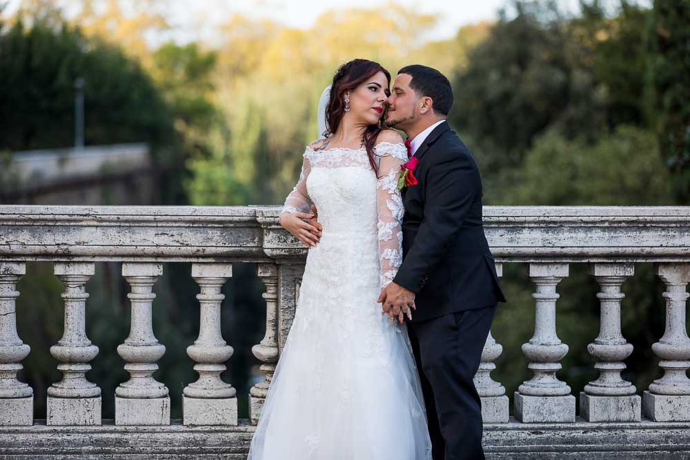 Posed picture of the newlyweds together by a marble balconnade