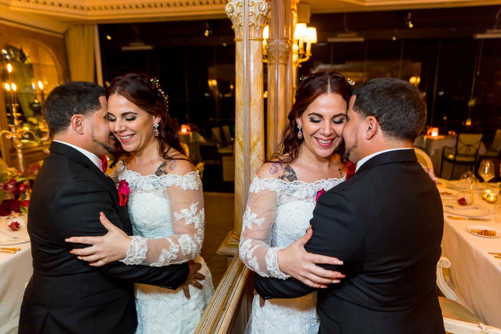 Picture of the bride & groom together photographed standing next to a mirror reflection